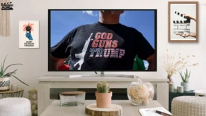 Movie Still - Man wearing tshirt, 'God Guns Trump' printed on it - Where to Watch God & Country The Rise of Christian Nationalism Documentary